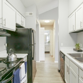 Galley  kitchen with white cabinets and black appliances