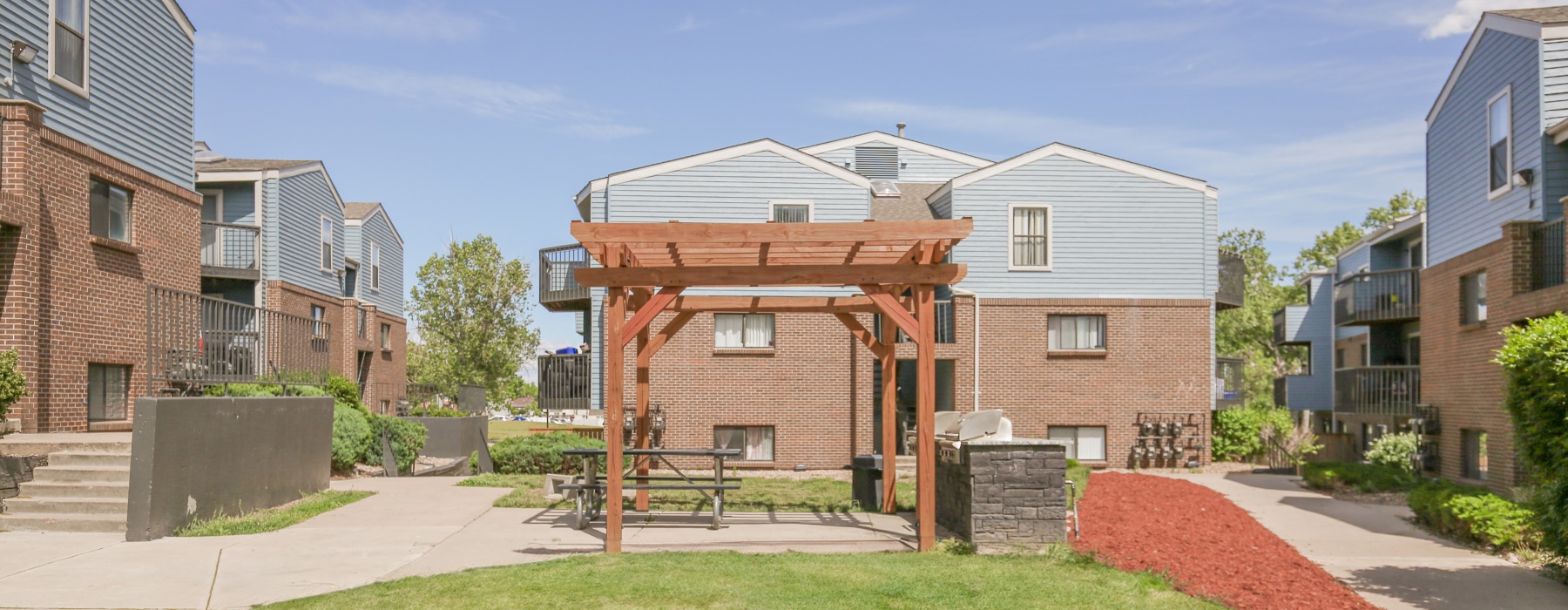 Grilling area under pergola in the middle of apartment buildings